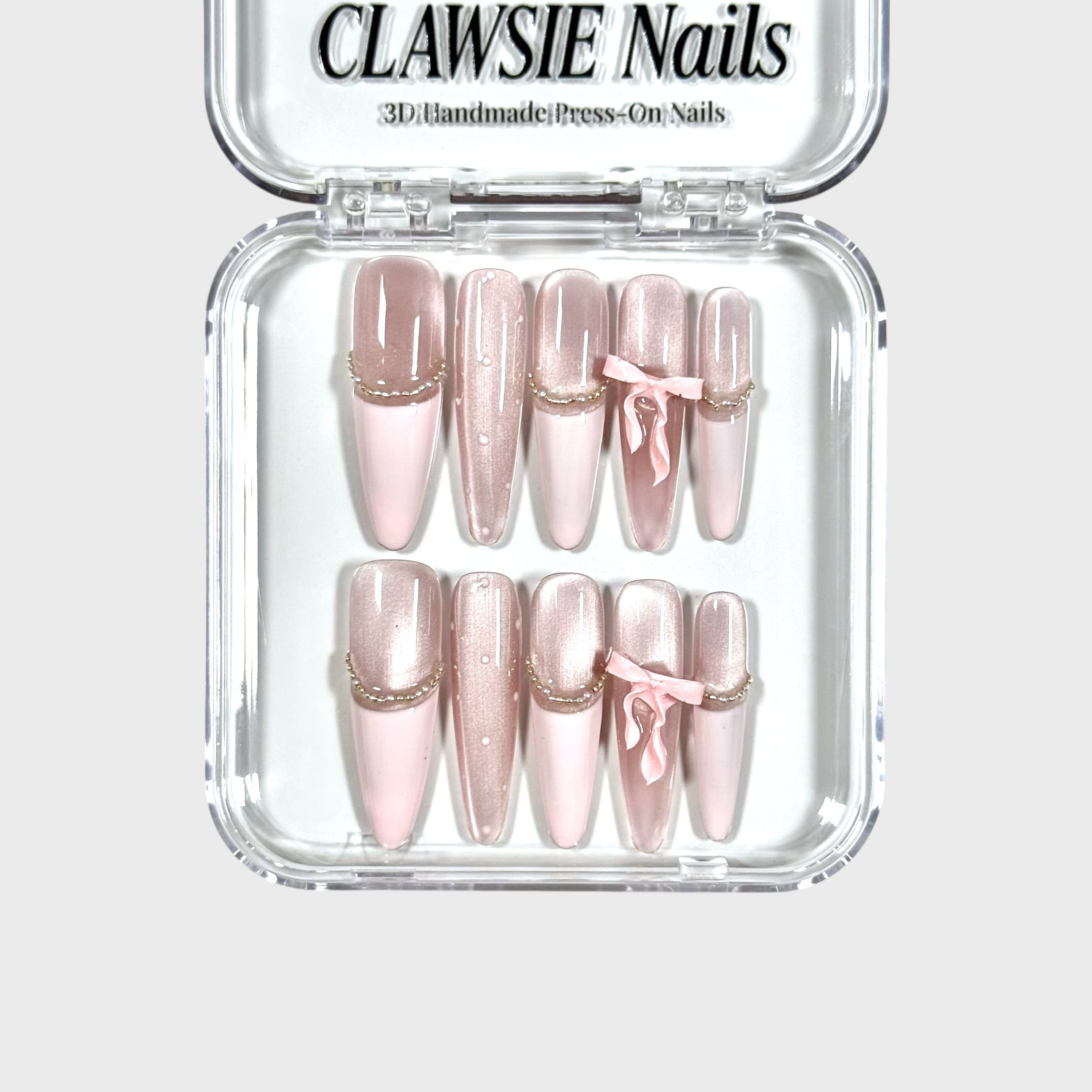 Set of pink press-on nails with gold accents in a clear case, branded 'CLAWSIE Nails'.