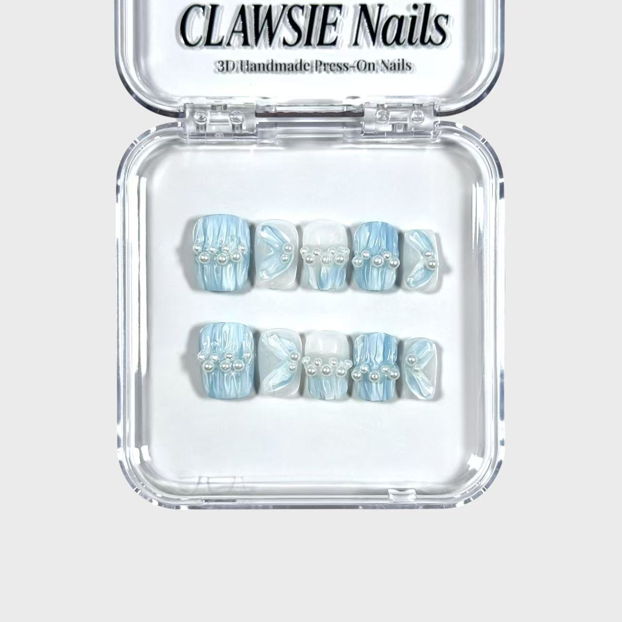 Set of blue and white marbled press-on nails in a clear packaging case with 'CLAWSIE Nails' branding.