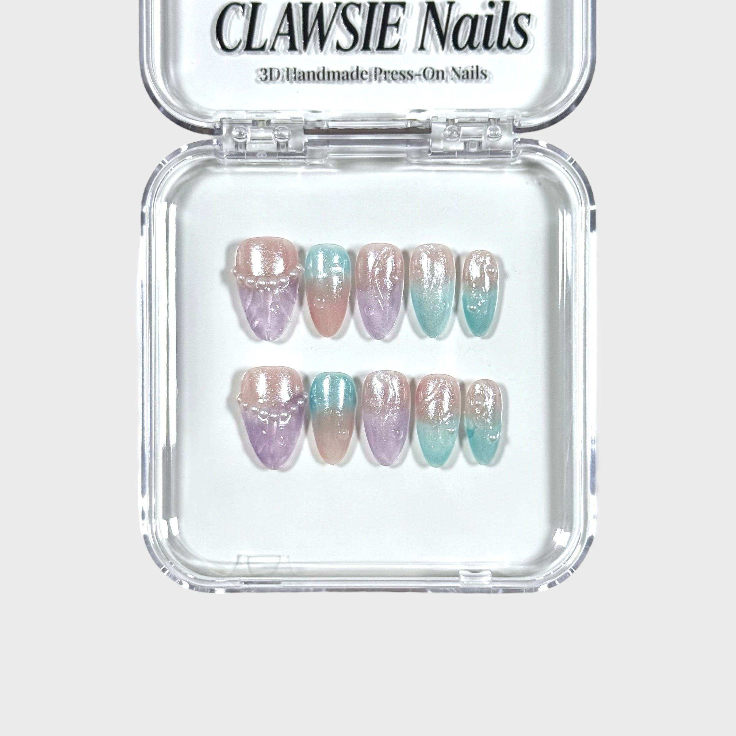 Set of 3D handmade press-on nails in pastel colors with 'CLAWSIE Nails' packaging.